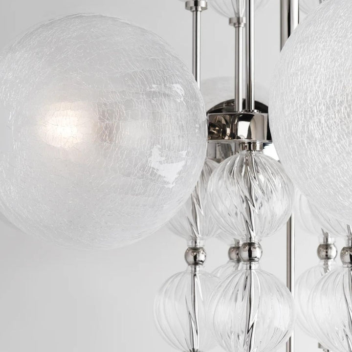 Chandelier with elegant glass globe shades and a modern charm, finished in aged brass.