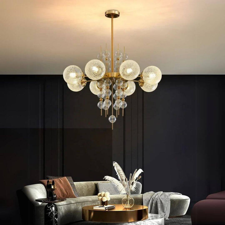 Chandelier featuring elegant glass globe shades with modern charm, finished in aged brass, enhancing the sophistication of any living space